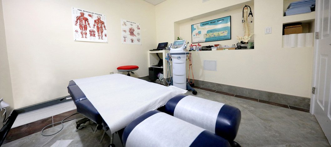 Treatment room with chiropractic table and therapy equipment